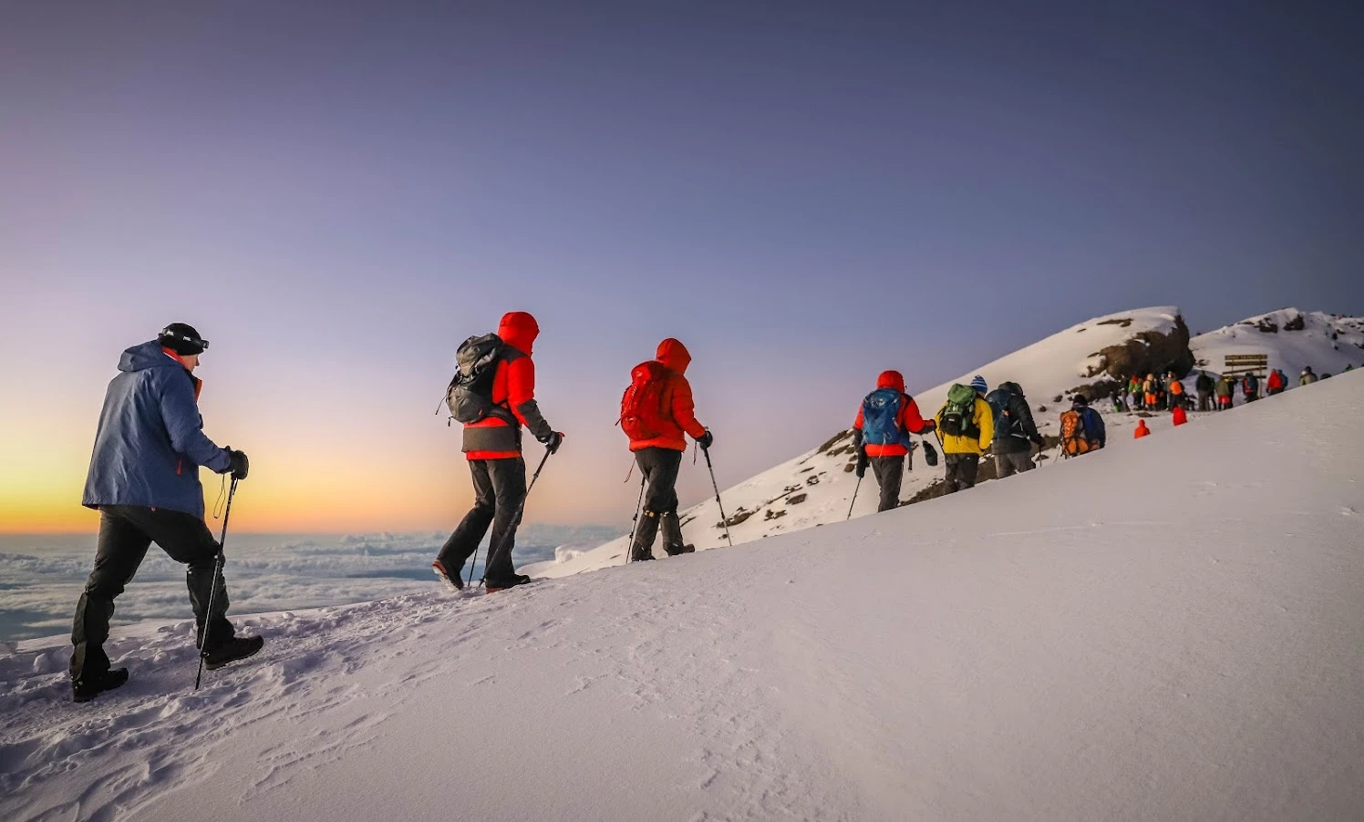 Trekkers climbing Mount Kilimanjaro via the Marangu Route with views of the snow-capped summit