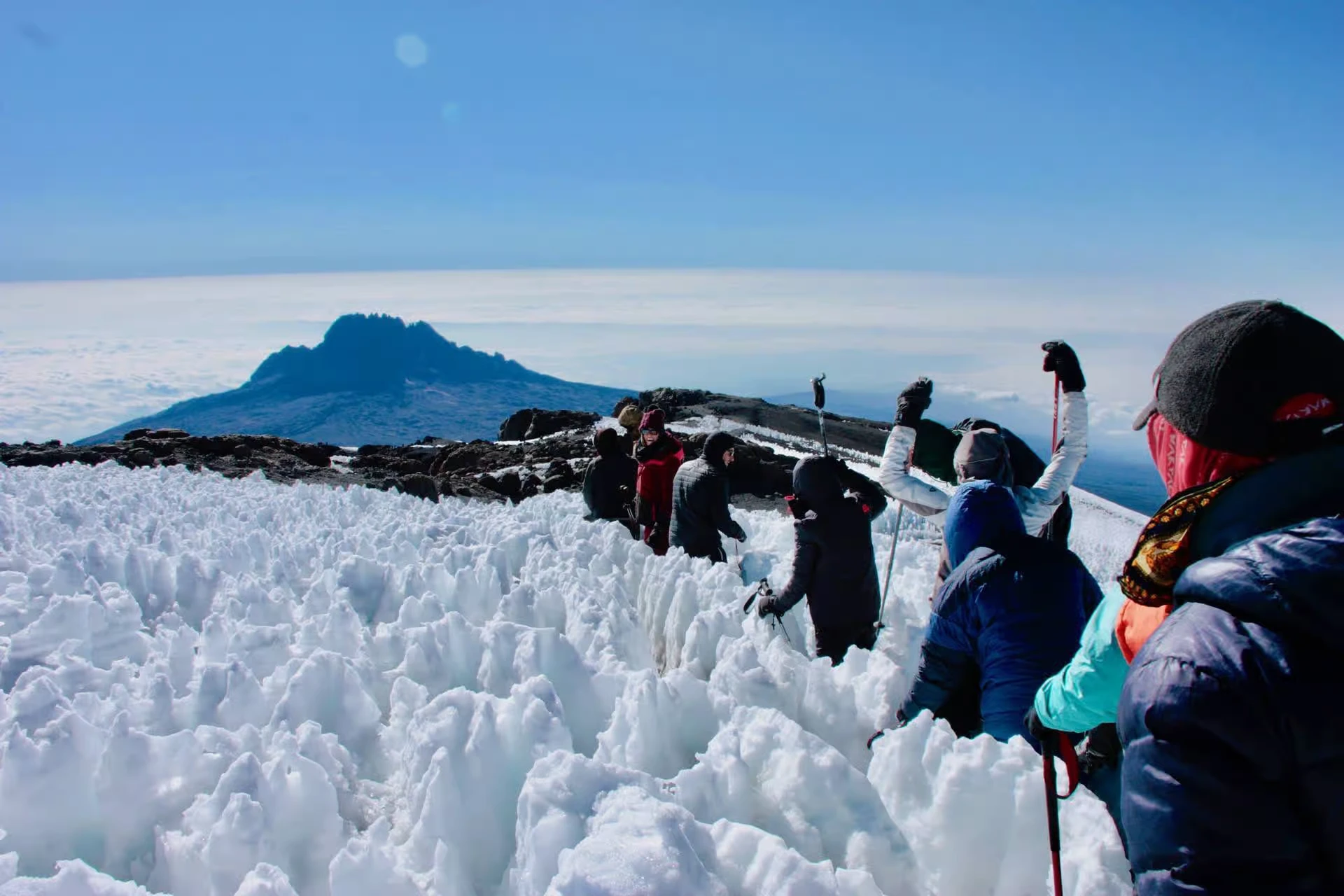 Trekkers hiking Mount Kilimanjaro via the remote Rongai Route under clear blue skies