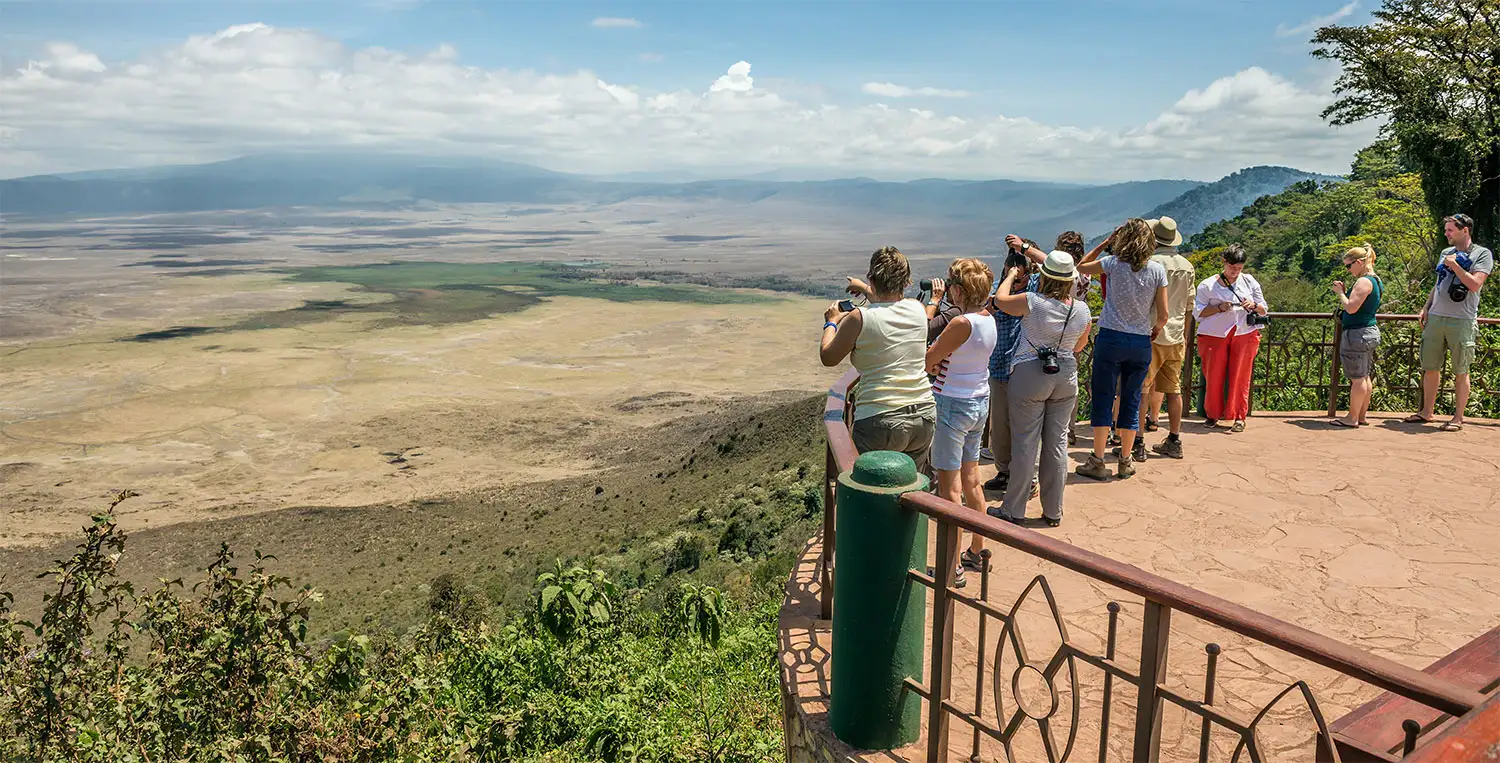 A wide view of Ngorongoro Crater filled with tourists exploring its scenic landscapes – Ngorongoro Crater travel advice.