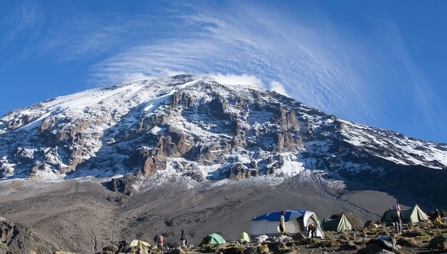 Hikers ascending Mount Kilimanjaro via the Lemosho Route, surrounded by remote wilderness and panoramic mountain scenery.