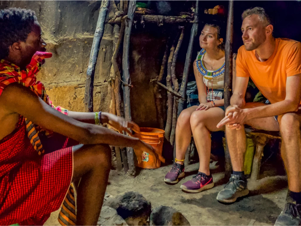 Visitors engaging with local Tanzanian communities, experiencing traditional dances, crafts, and daily life.
